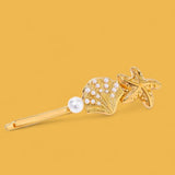 The Coastal Treasure Hair Pin: A golden shell and starfish.