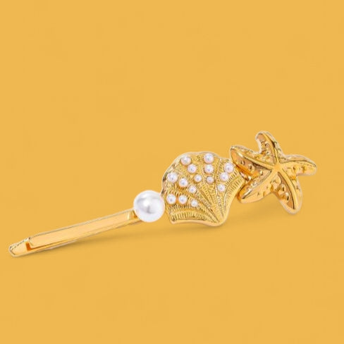 The Coastal Treasure Hair Pin: A golden shell and starfish.